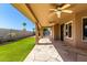 Covered patio with ceiling fans and decorative stone flooring overlooking artificial turf at 6543 E Preston St, Mesa, AZ 85215