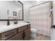 Bathroom with a light wood look floor, brown vanity, large mirror and decorative shower curtain at 759 E Zesta Ln # 104, Gilbert, AZ 85297