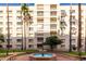 Exterior view of a multi-story building with palm trees surrounding a water fountain and well-maintained green spaces at 7830 E Camelback Rd # 108, Scottsdale, AZ 85251