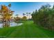 Lush green golf course tee box with palm trees and a pond in the background, offering a serene view at 7830 E Camelback Rd # 108, Scottsdale, AZ 85251