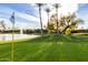 Lush golf course scene with a pond, palm trees, blue sky, and a flag waving in the breeze at 7830 E Camelback Rd # 108, Scottsdale, AZ 85251