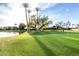 Picturesque golf course with well-manicured green, water feature, and palm trees at 7830 E Camelback Rd # 108, Scottsdale, AZ 85251