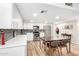 Bright kitchen featuring white cabinets, stainless appliances, and a modern backsplash, complemented by a dining area at 7830 E Camelback Rd # 108, Scottsdale, AZ 85251