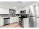 This spacious kitchen is complete with stainless steel appliances, white cabinets, and a decorative backsplash at 7830 E Camelback Rd # 108, Scottsdale, AZ 85251