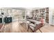 Inviting living room with wood floors, designer furniture, and a wall of built-in bookshelves near the balcony at 7830 E Camelback Rd # 108, Scottsdale, AZ 85251