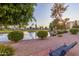 Picturesque pond featuring mature trees, a fountain, manicured landscaping, and a relaxing bench at 7830 E Camelback Rd # 108, Scottsdale, AZ 85251