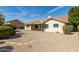 Backyard with a covered patio, low-maintenance gravel landscaping, and mature trees, enhancing privacy at 817 E Meadow Ln, Phoenix, AZ 85022