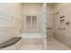 Bathroom featuring large soaking tub, glass block divider, and tiled shower for a spa-like retreat at 817 E Meadow Ln, Phoenix, AZ 85022