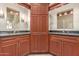 Dual sink bathroom featuring granite counters, wood cabinetry, and modern lighting for added luxury at 817 E Meadow Ln, Phoenix, AZ 85022