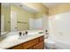 Bathroom featuring a wooden cabinet sink, framed mirror, tile wall, and shower with bathtub at 817 E Meadow Ln, Phoenix, AZ 85022