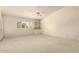 Spacious carpeted bedroom featuring built-in shelving, a ceiling fan, and a bright window at 817 E Meadow Ln, Phoenix, AZ 85022