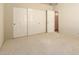 Carpeted bedroom featuring built-in white closet with sliding doors, perfect for ample storage and organization at 817 E Meadow Ln, Phoenix, AZ 85022