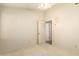 Neutral bedroom with white carpet, ceiling fan, and view of a hallway with a partially open door at 817 E Meadow Ln, Phoenix, AZ 85022