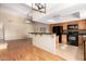 Open-concept kitchen featuring wooden cabinets, granite countertops, black appliances, and hardwood floors at 817 E Meadow Ln, Phoenix, AZ 85022