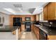 Well-equipped kitchen with stone countertops, oak cabinetry, and black appliances for culinary enthusiasts at 817 E Meadow Ln, Phoenix, AZ 85022