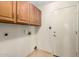 Laundry room with wooden cabinets, utility hookups and access door at 817 E Meadow Ln, Phoenix, AZ 85022