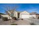 Beige single-story home with a two car garage, desert landscaping, and a light tile roof at 821 S Parker Pl, Casa Grande, AZ 85122