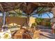 Comfortable backyard cabana with decorative pillows and wooden furniture at 8305 W Pioneer St, Tolleson, AZ 85353