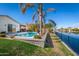 Backyard featuring a pool, patio, lush lawn, a lake with black fence, and mature palm trees at 856 E Indian Wells Pl, Chandler, AZ 85249