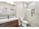 Modern bathroom with a glass-enclosed shower, brown vanity with sink, decorative mirror and mosaic tile accents at 856 E Indian Wells Pl, Chandler, AZ 85249