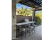 Outdoor kitchen featuring a built in stainless steel grill, bar seating and outdoor lighting at 856 E Indian Wells Pl, Chandler, AZ 85249