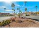 Community entrance with desert landscaping, palm trees, and flowering shrubs, creating an inviting first impression at 9151 W Greenway Rd # 258, Peoria, AZ 85381