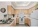 Clean kitchen featuring white appliances, light wood cabinets, and plenty of counter space at 9151 W Greenway Rd # 258, Peoria, AZ 85381