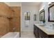 Bathroom featuring a tub, walk-in shower, double sink vanity, and a bright window at 9214 N 83Rd St, Scottsdale, AZ 85258