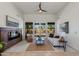 Bright living room featuring a fireplace, white sofa, ceiling fan, and French doors leading to the backyard at 9214 N 83Rd St, Scottsdale, AZ 85258