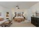 Spacious main bedroom featuring a wood platform bed, seating area, ceiling fan, and bright natural light at 9214 N 83Rd St, Scottsdale, AZ 85258