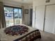 Bright bedroom with slider to patio, beige carpet, and white walls and sliding closet doors at 925 E Lancaster Cir, Florence, AZ 85132