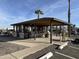 View of the community clubhouse with open air seating and mature landscaping in the area at 925 E Lancaster Cir, Florence, AZ 85132