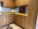 This traditional kitchen features wood cabinets and drawers, a microwave, and view to the dining area at 925 E Lancaster Cir, Florence, AZ 85132