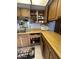 This kitchen features wood cabinets, a double basin sink and a white microwave at 925 E Lancaster Cir, Florence, AZ 85132