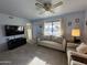 Inviting living room with plush sofa, ceiling fan, and bright, sunny window at 925 E Lancaster Cir, Florence, AZ 85132