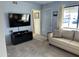 Comfortable living room with neutral walls, modern TV setup, and ample natural light at 925 E Lancaster Cir, Florence, AZ 85132