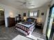 Cozy bedroom with ceiling fan, dresser, and a large sliding glass door to the outside at 925 E Lancaster Cir, Florence, AZ 85132