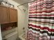 Shower area featuring a striped curtain, shower head, and wall-mounted cabinet at 925 E Lancaster Cir, Florence, AZ 85132