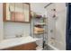 Bathroom featuring a mirror cabinet, bathtub with shower, and a storage rack at 9283 W Rafael Dr, Arizona City, AZ 85123