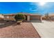 Single level home showcasing desert landscaping, a two car garage, and a front entrance with gate at 9283 W Rafael Dr, Arizona City, AZ 85123