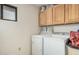 Functional laundry room with cabinets and white washer and dryer units at 9283 W Rafael Dr, Arizona City, AZ 85123