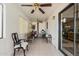 Bright sun room with tile flooring, ceiling fans, and a glass sliding door at 9283 W Rafael Dr, Arizona City, AZ 85123