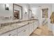 Bright bathroom with double sink vanity and granite countertops and a view into a large walk-in closet and marble shower at 9410 N 18Th St, Phoenix, AZ 85020