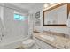 Bright bathroom with marble backsplash, a shower and tub combination and mountain views from the window at 9410 N 18Th St, Phoenix, AZ 85020