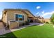 Desert backyard with artificial turf and a covered patio extends from the house, perfect for outdoor entertaining at 9610 E Trent Ave, Mesa, AZ 85212