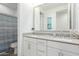 Bathroom features dual sinks, modern fixtures, white cabinets, and neutral countertops with a decorative ocean-themed design at 9610 E Trent Ave, Mesa, AZ 85212