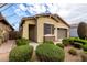 A well-kept home displaying verdant bushes and a neutral color scheme, complete with a two-car garage at 9610 E Trent Ave, Mesa, AZ 85212