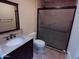 Bathroom featuring tiled shower, granite vanity, and brushed bronze fixtures at 10116 W Bolivar Dr, Sun City, AZ 85351