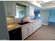 Kitchen featuring white cabinets, sleek black appliances and granite countertops at 10116 W Bolivar Dr, Sun City, AZ 85351
