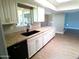 The kitchen features white cabinets and a black sink and faucet and granite countertops at 10116 W Bolivar Dr, Sun City, AZ 85351